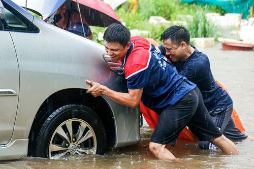 Ô tô ngập nước nằm la liệt trong khu chung cư Hà Nội, chủ xe hì hục giải cứu