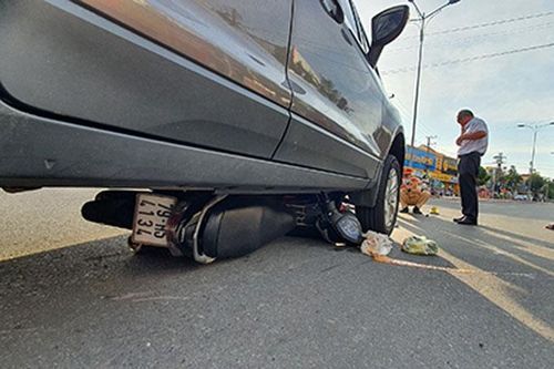 Xe máy bị cuốn vào gầm ô tô, người điều khiển may mắn thoát nạn