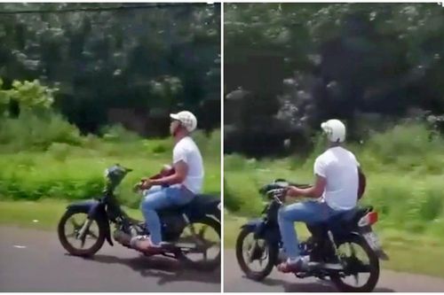 Thanh niên lái xe bằng chân, vừa chạy vừa đánh đàn ghi-ta vì đang đi cảm thấy buồn