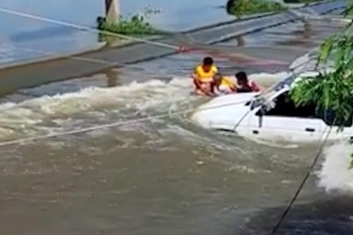 Ô tô đi qua đập tràn ở Thái Lan, hai người bị mắc kẹt