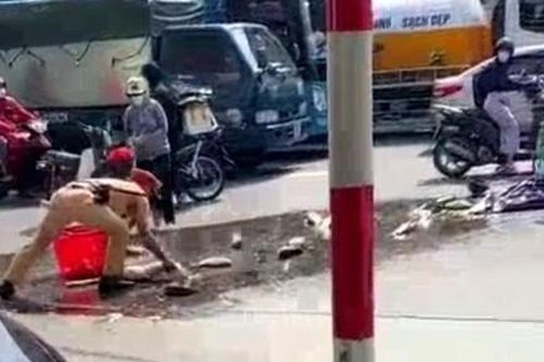 CSGT giúp người dân thu gom cá bị đổ trên đường phố