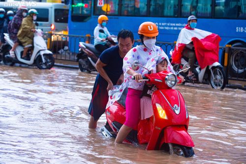 Người dân TP.HCM bì bõm lội nước về nhà sau cơn mưa lớn kéo dài hàng giờ