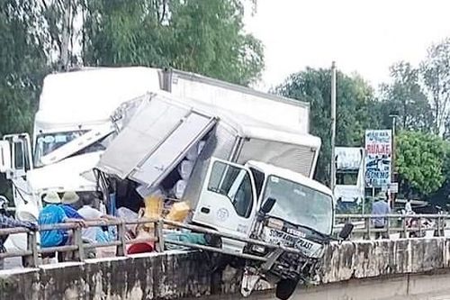 Xe tải nằm gọn trên thành cầu sau cú va chạm với xe container
