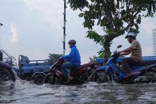 Người dân TPHCM bì bõm về nhà khi triều cường dâng cao