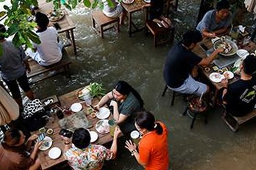 Khách ngồi 'nhậu' giữa biển nước lụt ở Thái Lan, vừa ăn vừa chơi với cá