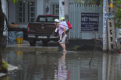 TP.HCM: Triều cường dâng cao, phụ huynh lội nước cõng con đi học