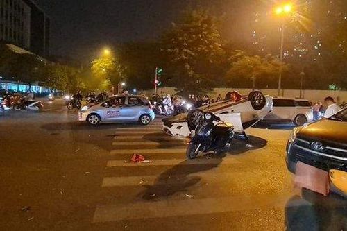 Ô tô phóng nhanh hất văng 2 người trên xe máy rồi lật ngửa giữa phố ở Hà Nội