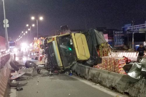 Xe tải lật trên quốc lộ 1, hàng chục thùng bia tràn xuống đường