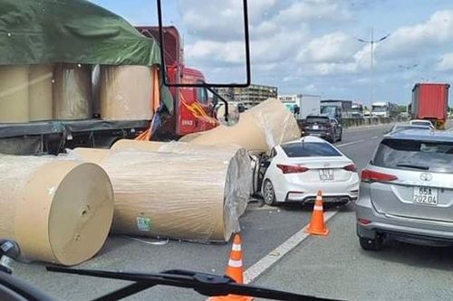 Cuộn giấy rơi từ thùng xe đầu kéo đè nát đầu xe con