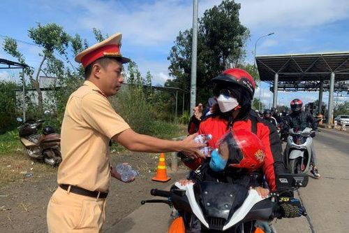 Cảnh sát giao thông Đắk Nông phát nước uống, bánh mì cho người dân trở lại sau Tết