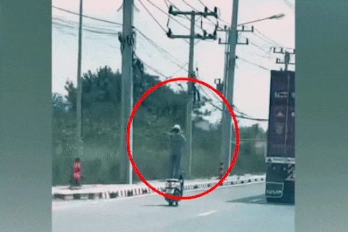 Tài xế liều lĩnh đứng trên yên xe đang chạy