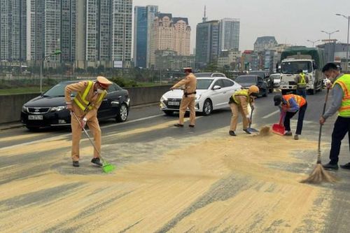 CSGT giúp lái xe thu dọn nhiều bao tải cám rơi trên đường Vành đai 3