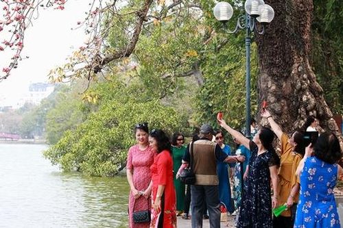 Chị em tấp nập check in cây hoa gạo trăm tuổi bên hồ Gươm