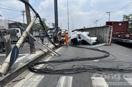 Xe tải cẩu quên hạ cẩu, kéo gãy trụ điện trên đường rồi lật nhào