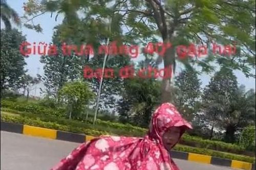 Đôi trẻ mặc áo mưa đi trong 'chảo lửa' Hà Nội