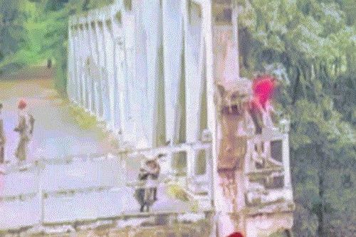 Camera ghi lại cảnh người đàn ông leo qua lan can cầu rồi bất ngờ nhảy xuống sông