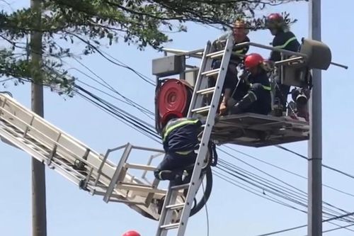 Cảnh sát dùng xe thang giải cứu nam thanh niên cố thủ trên cột đèn