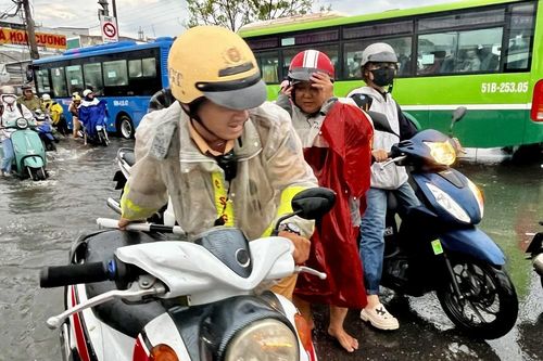 CSGT Thành phố Hồ Chí Minh giúp người dân vượt qua khu vực ngập úng
