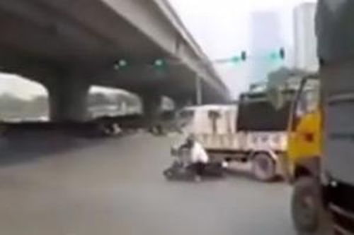 Hà Nội: luồn lách sai làn, tài xế xe máy trượt ngã vào ô tô tải
