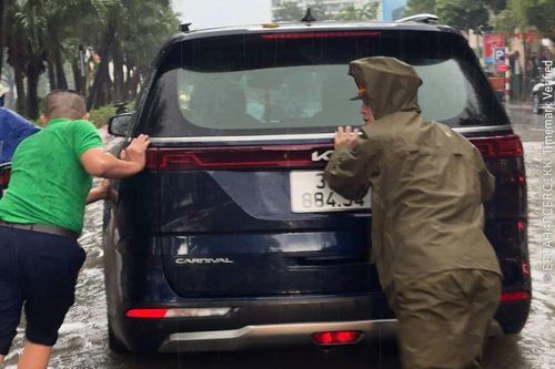 Công an phường Ngọc Hà hỗ trợ người dân đi qua khu vực ngập úng