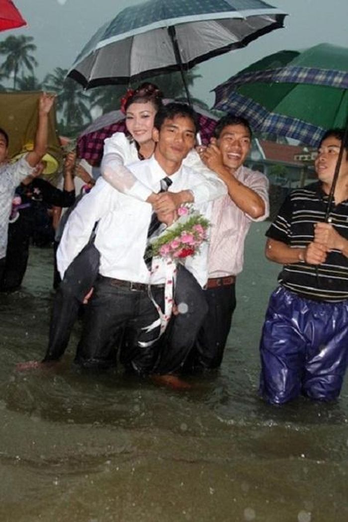Chú rể bì bõm lội nước cõng cô dâu đi qua cánh đồng ngập trắng nước trong đám cưới của mình tại Hương Sơn, Hà Tĩnh
