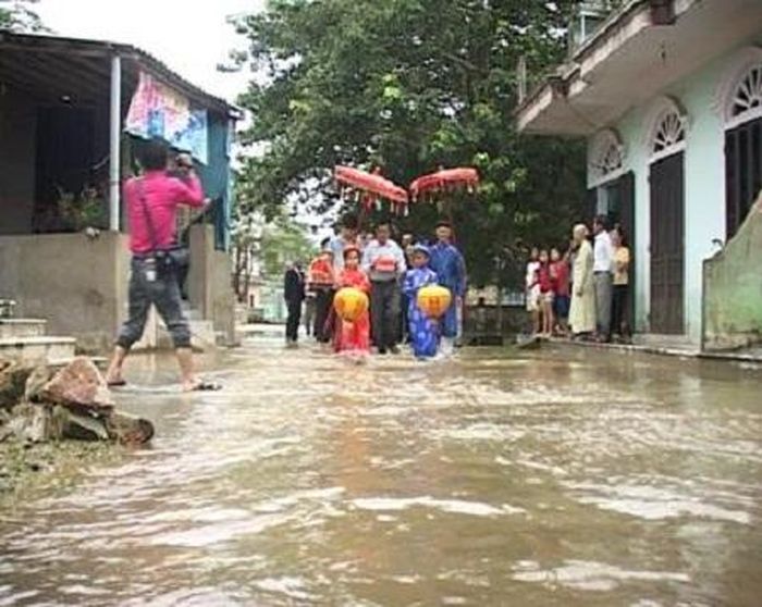 Đoàn rước dâu họ nhà trai lội bì bỏm tiến vào nhà gái đón dâu trong đám cưới đôi bạn trẻ: Nguyễn Thành - Hồ Thị Thủy ở huyện Hương Trà (Huế) năm 2011