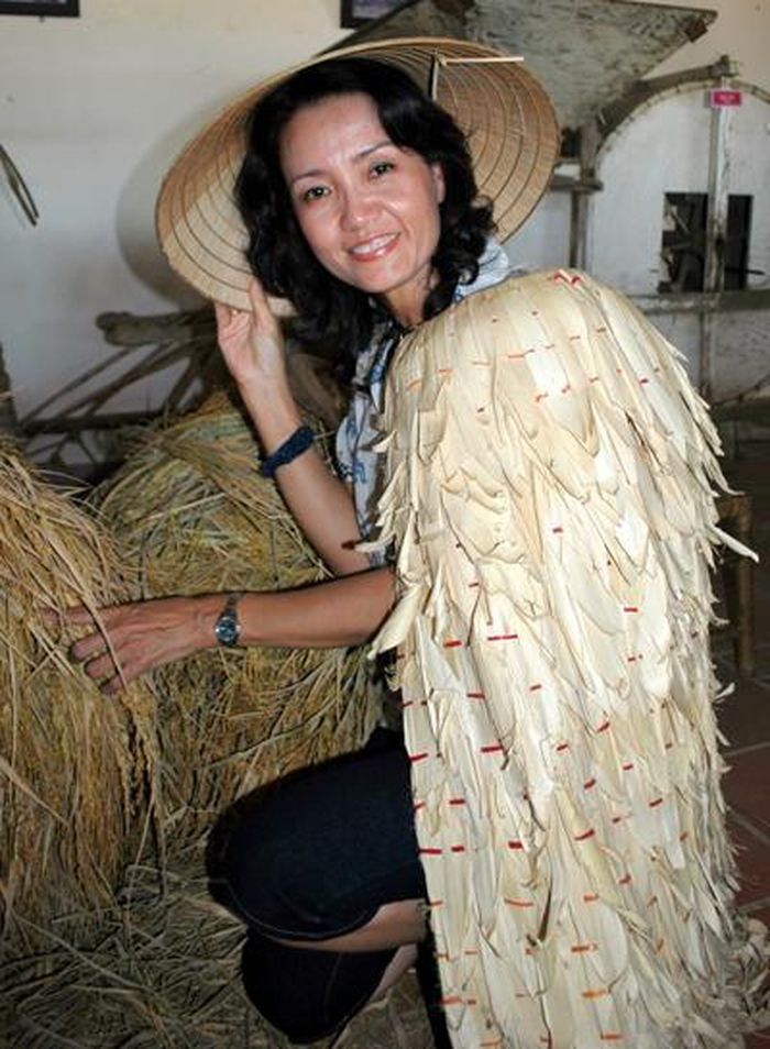 Du khách mặc thử “áo tơi” của nông dân