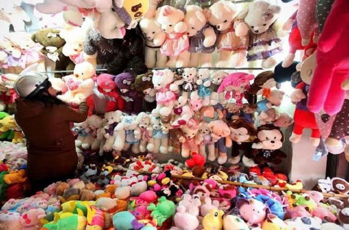 Dọc các tuyến đường Nguyễn Trãi, Cầu Giấy, Kim Mã… hàng trăm đồ chơi thú bông không có nhãn mác được đổ tràn ra chiếc bạt, chất thành từng đống lớn. Theo chị N (bán hàng tại vỉa hè Nguyễn Khang): “dọn hàng từ 5h30, bán đến 11h thì thôi, hôm nào mưa thì lấy bạt phủ lên. Nhiều thế này thì phải đổ đống cho dễ chọn chứ quầy nào, chỗ nào đặt lên cho đủ”. 