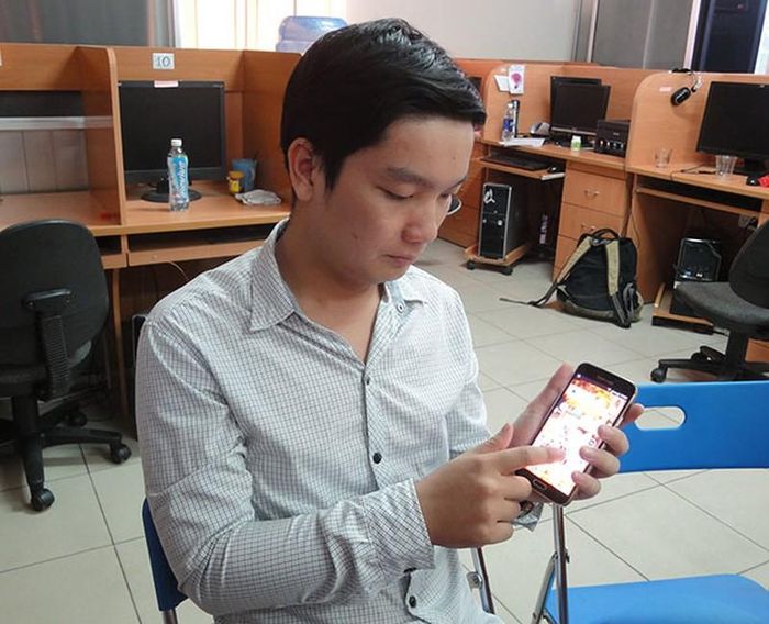 ThS Trần Minh Trường thử nhắm mắt dùng điện thoại có cài phần mềm hỗ trợ đọc tiếng Việt cho người khiếm thị. Ảnh: Tuổi trẻ.