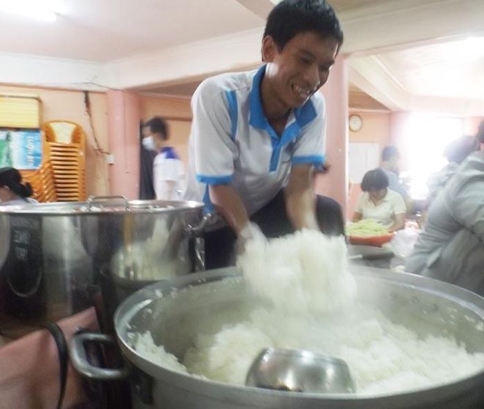 Em Lập đang xới cơm.