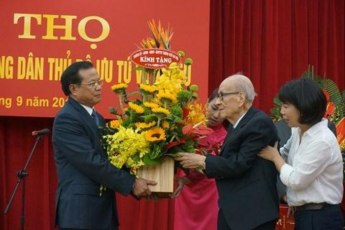 Bí Thư Thành ủy Hà Nội Phạm Quang Nghị tặng hoa Giáo sư Vũ Khiêu. Ảnh: Đinh Thị Thuận-TTXVN
