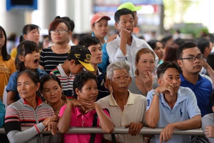  Hàng nghìn người chen lấn ngay trước cửa ra để đón người thân. Các dãy ghế chờ đã kín chỗ, nhiều người chen lấn lên phía trước buộc nhiều người trên ghế phải đứng lên ghế cho tiện quan sát người thân. 