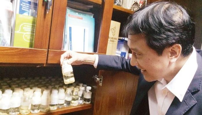 GS.TS Trịnh Hồng Sơn xem lại những kỷ niệm trong bộ sưu tập độc đáo. Ảnh: T.Hà.