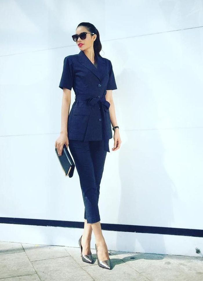 Hoa hậu Diễm Hương chọn phong cách thanh lịch với gam màu trầm khi dạo phố Tết. trong ảnh, thiết kế tông đen tối màu vừa vặn vóc dáng cao ráo. Phụ kiện túi, giày ánh kim làm điểm nhấn. 