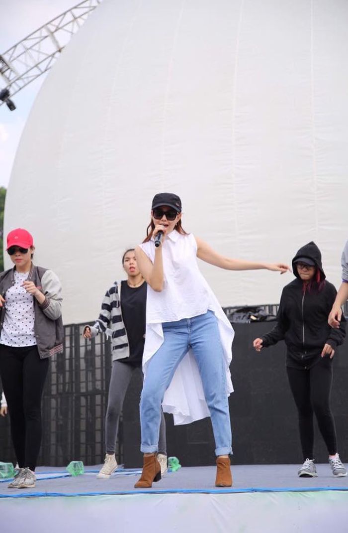 Quần jeans xanh được cô mix cùng áo sơ mi trắng kiểu high low lạ mắt.