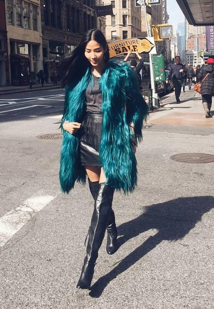 Trên đường phố New York, Hoàng Thùy sải bước với bộ cánh tối màu cá tính, boots cao cổ hiện đại. Áo khoác lông màu xanh bắt mắt.