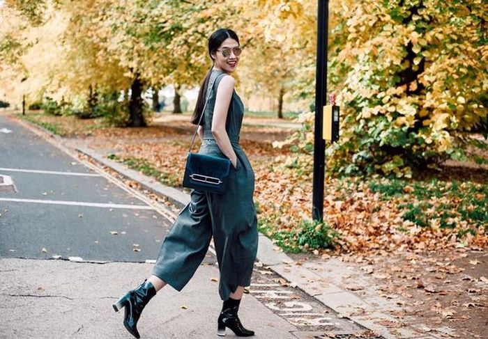 Người mẫu Thu Hằng sành điệu với bộ jumpsuits tông xanh đậm, phụ kiện boots da bóng, túi chất liệu nhung tôn vẻ thời thượng.
