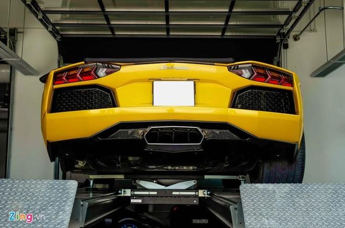 Chiếc Lamborghini Aventador đầu tiên tại Việt Nam có mặt từ sáng sớm. Các kỹ thuật viên của xưởng dùng máy nâng thủy lực đưa xe lên cao để thay lốp. 