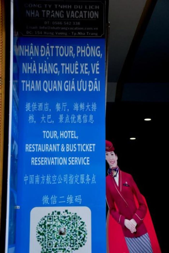 Một doanh nghiệp du lịch mở phòng vé máy bay treo biển hiệu chữ Trung Quốc trên đường phố Nha Trang. (Ảnh: Minh Hoàng)