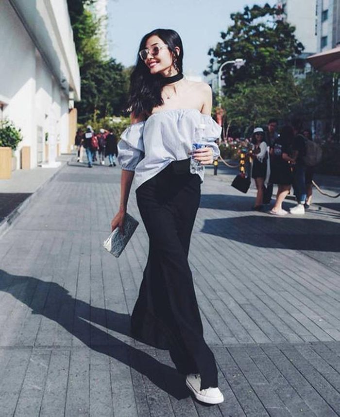 Hoàng Thùy với lựa chọn áo trễ vai và quần xẻ ống đầy cá tính.