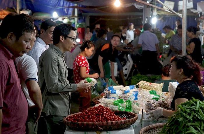 Photo: Phó Thủ tướng Vũ Đức Đam trò chuyện với tiểu thương chợ Long Biên (ảnh ĐN)