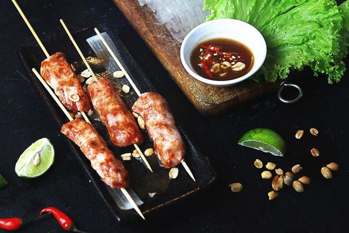  Nem nướng cuốn bánh tráng kèm rau sống, chấm nước sốt sền sệt là món được rất nhiều khách yêu thích. 