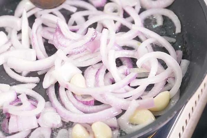 Bước 3: Làm nóng chảo, cho dầu ô liu, hành tây, tỏi và một chút muối vào nấu xào chín.