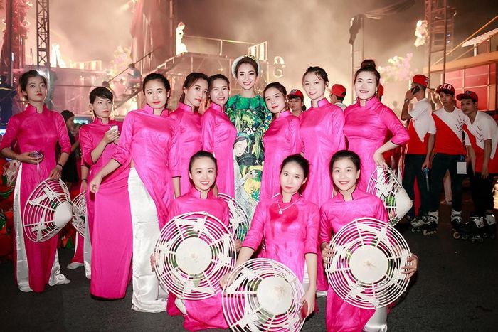 Jennifer Phạm chụp ảnh cùng các vũ công mặc áo dài hồng rực rỡ. Cô rất được ngưỡng mộ vì nhan sắc xinh đẹp.