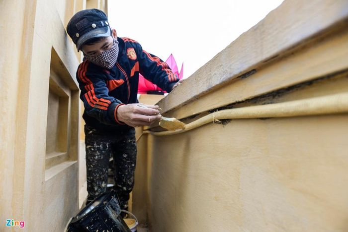 Một công nhân vệ sinh đang hoàn thiện nốt việc phủ vôi lên ống dẫn. 