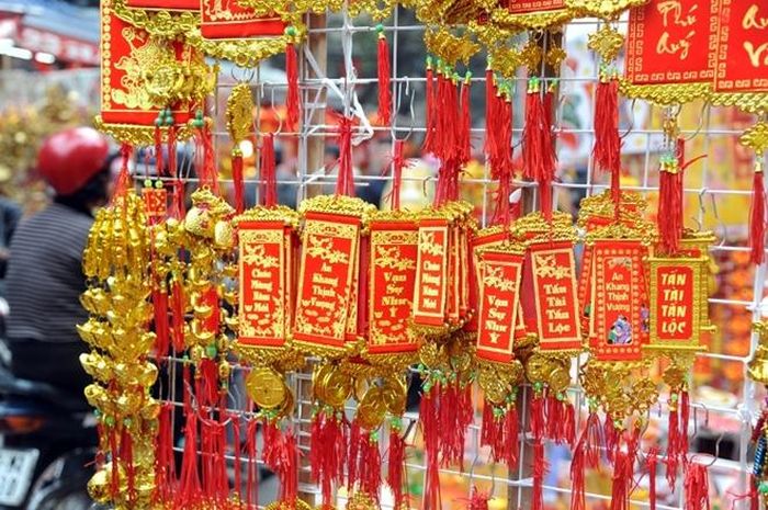 Cả tuyến phố đỏ rực đèn lồng và vàng óng những sợi dây kim tuyến với nhiều câu chúc phúc. 