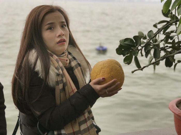 ... thì bỗng nhiên khuôn mặt biến sắc khi thấy quả bưởi bất ngờ rụng và rơi vào lòng bàn tay mình.