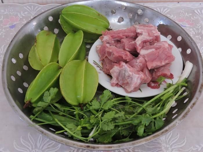 Sườn kho khế. Cho chảo lên bếp, đợi chảo nóng rồi cho dầu và đường để làm nước hàng. Tiếp tục cho tỏi, sả, ớt băm vào phi thơm rồi cho sườn vào xào săn lại. Sau cùng cho thêm nước dừa vào đảo đều, đậy nắp đun với lửa nhỏ để miếng sườn được ngấm đều và mềm. Ảnh: Tienphong.