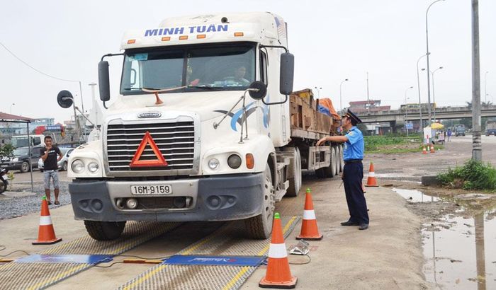 Cân tải trọng xe tại Trạm cân lưu động trên địa bàn huyện Thanh Trì. Ảnh: Chiến Công