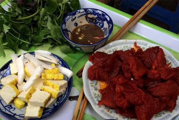 5. Gỏi sứa đỏ. Sứa cắt thành những tảng lớn, ngâm trong nước hãm làm từ cây sú vẹt. Khi ăn, bạn lấy một chiếc lá tía tô và kinh giới, đặt lên trên một miếng sứa, một miếng đậu nướng, một miếng dừa non, cuộn lại và chấm với mắm tôm. Miếng sứa biển thanh mát, giòn giòn kết hợp với miếng đậu phụ nướng mềm bùi, cùi dừa béo ngậy đem lại cảm giác mới lạ đầy thú vị. Một chút mắm tôm đánh kỹ với quất và ớt tươi cùng với rau kinh giới, tía tô giúp món ăn càng đậm đà hơn. Ảnh: giadinh.net.vn. 